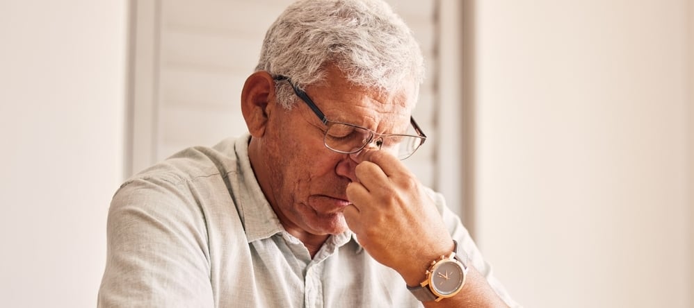 Worried retiree man sitting thinking.