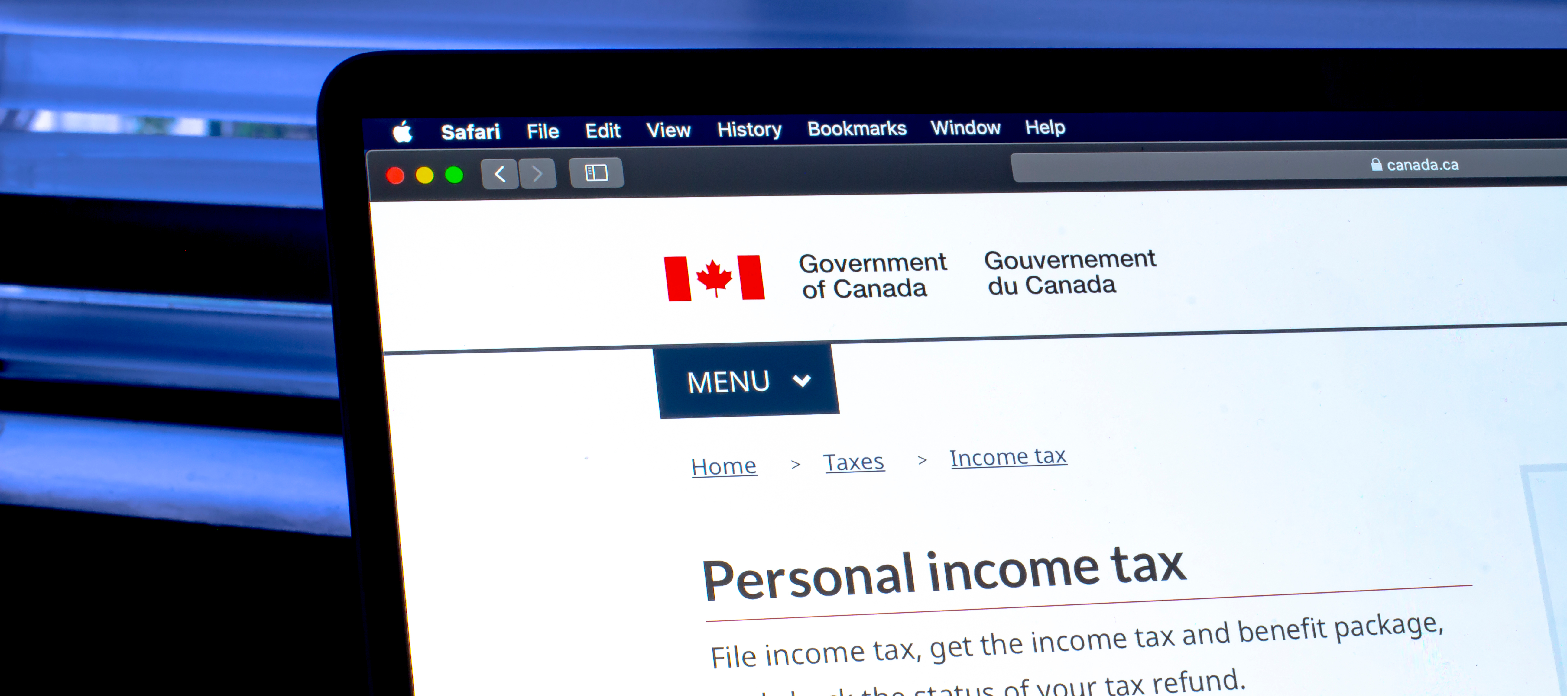 A laptop with the Government of Canada tax revenue website on the screen.