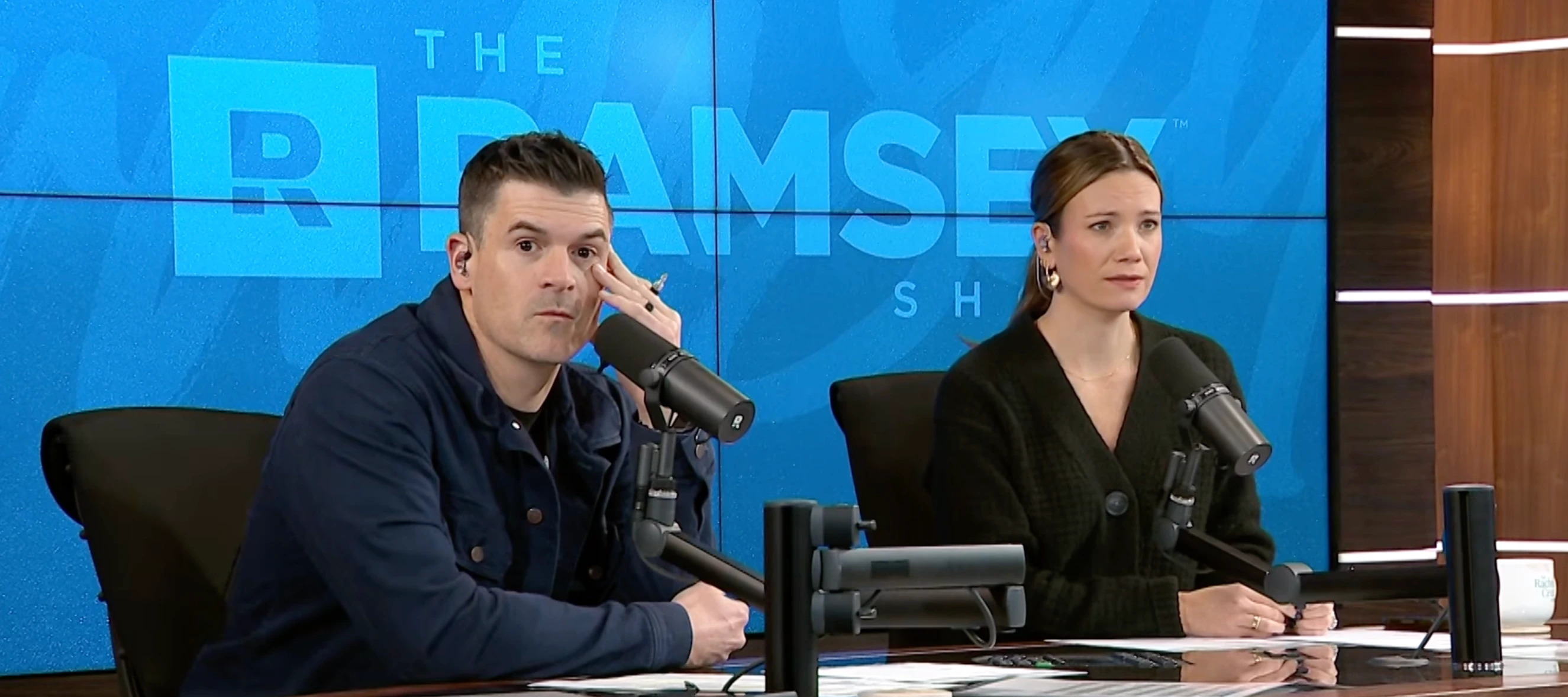 Cohosts sitting at a podcast table