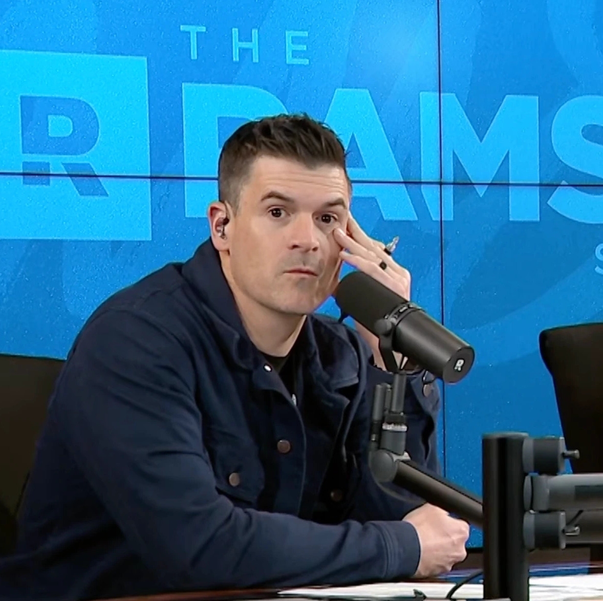 Cohosts sitting at a podcast table