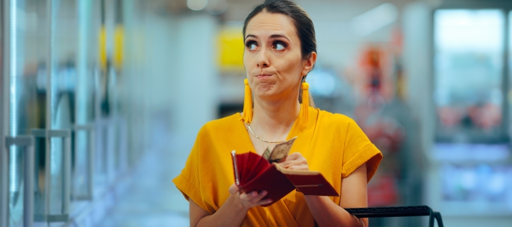 Stressed woman shopping and counting cash