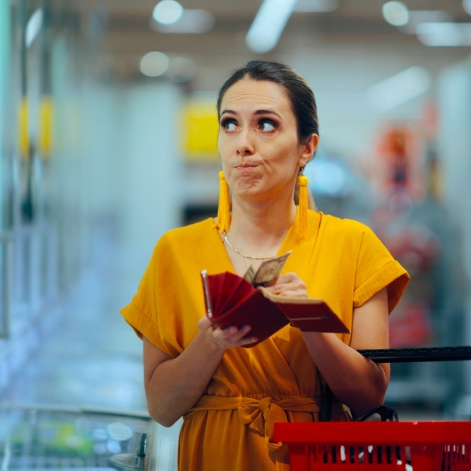 Stressed woman shopping and counting cash