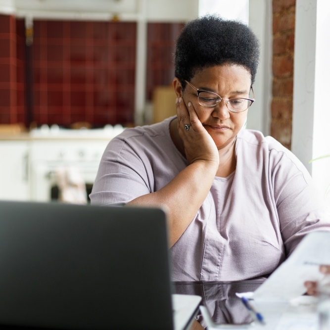 Middle-aged black woman reviewing financial documents