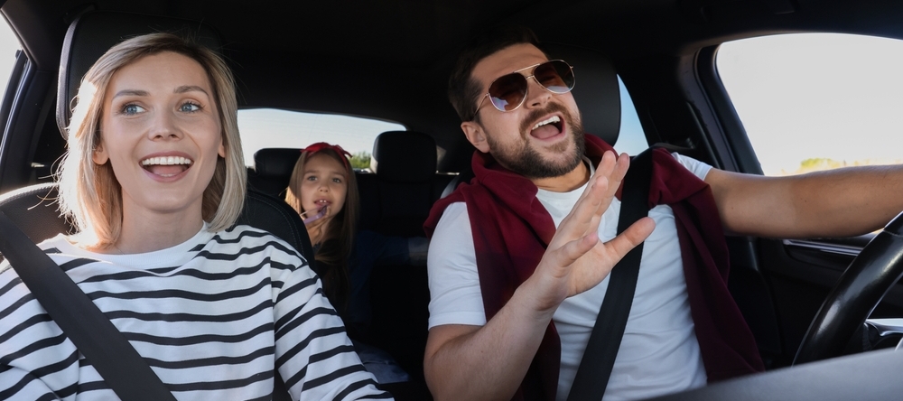 Happy family singing in the car during a road trip