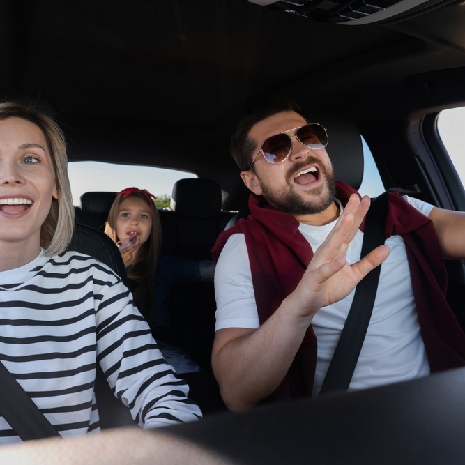 Happy family singing in the car during a road trip