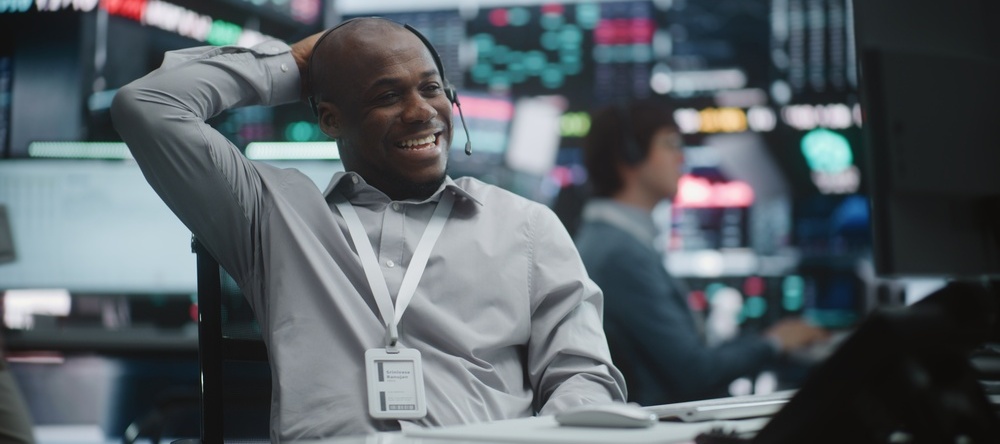 Active trader laughing while chatting on a headset
