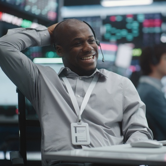 Active trader laughing while chatting on a headset
