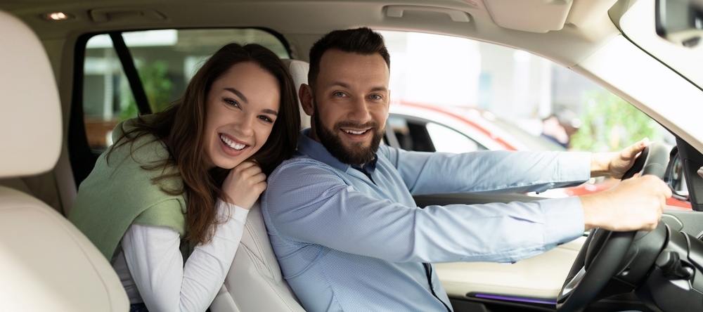 Male and female in car smiling