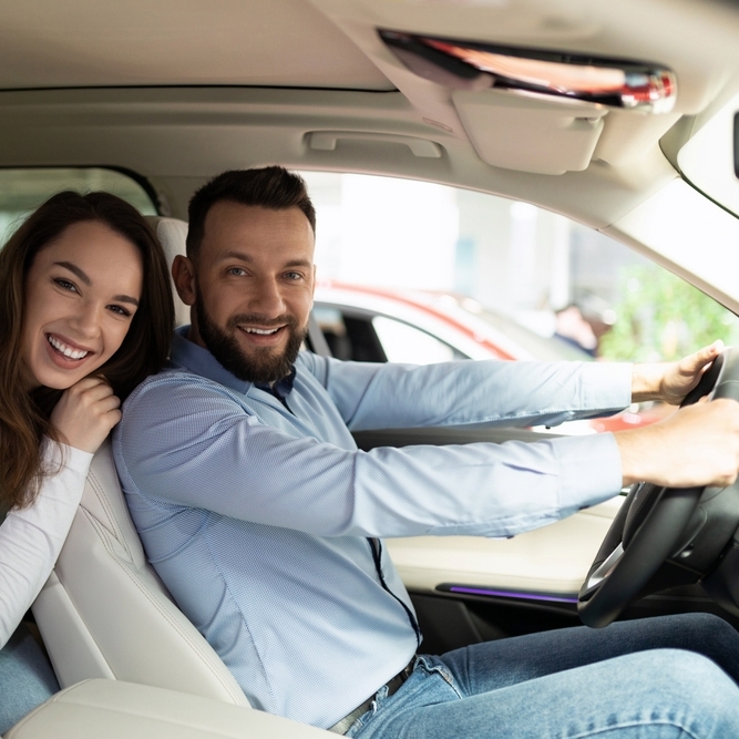 Male and female in car smiling