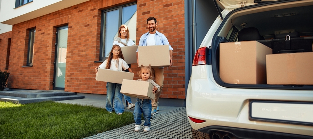 Family of 4 holding moving boxes