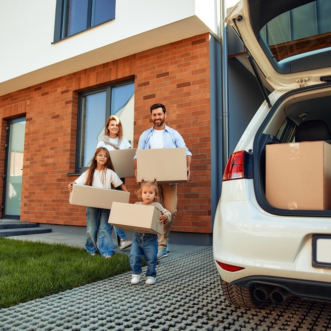 Family of 4 holding moving boxes