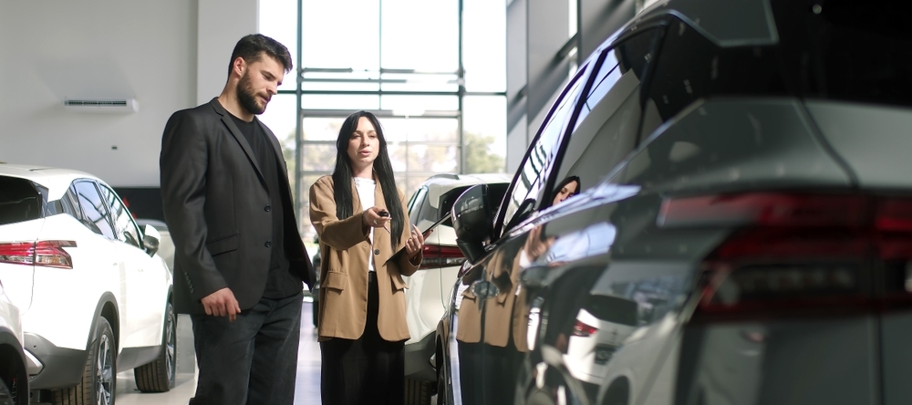 A man buying a car off a female car salesperson