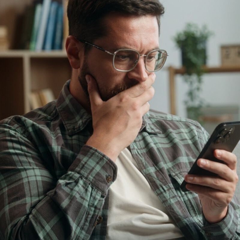 Photo of CRA sign and image of man looking shocked while holding his phone