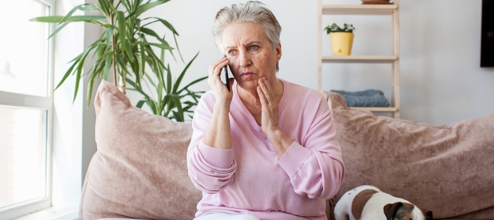 A woman sitting on the couch on the phone