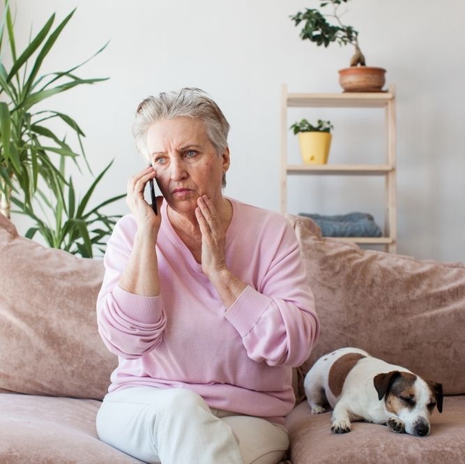 A woman sitting on the couch on the phone