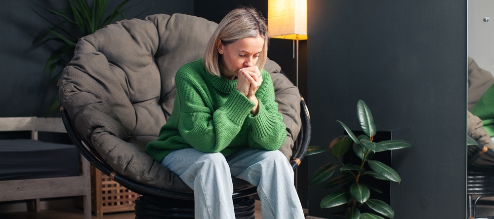 Woman sitting on chair looking stressed