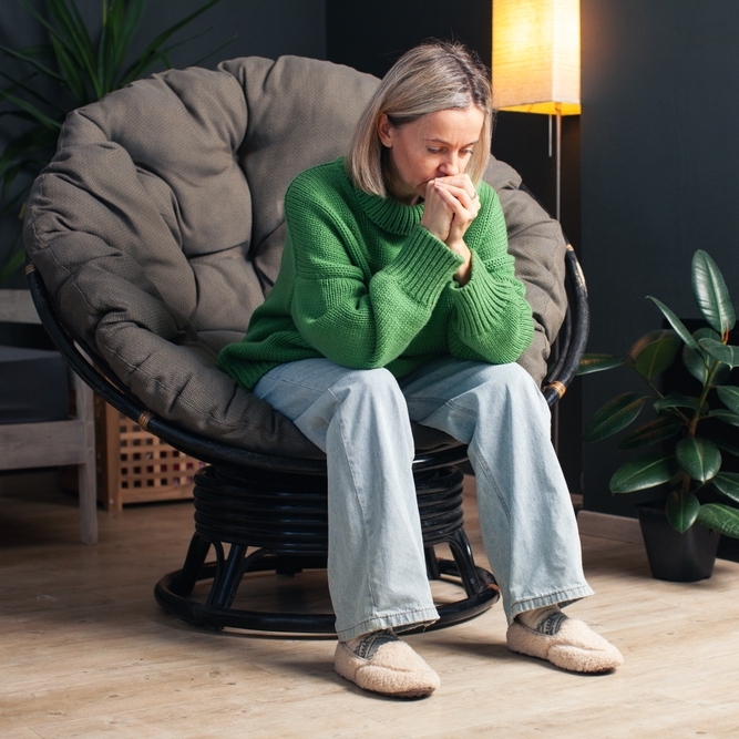 Woman sitting on chair looking stressed