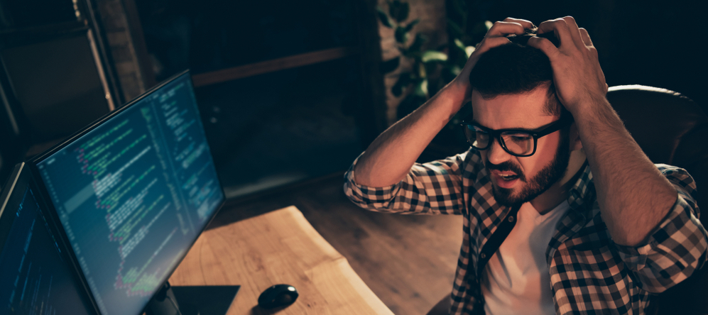 Adult man looking frustrated as he stares at a computer screen