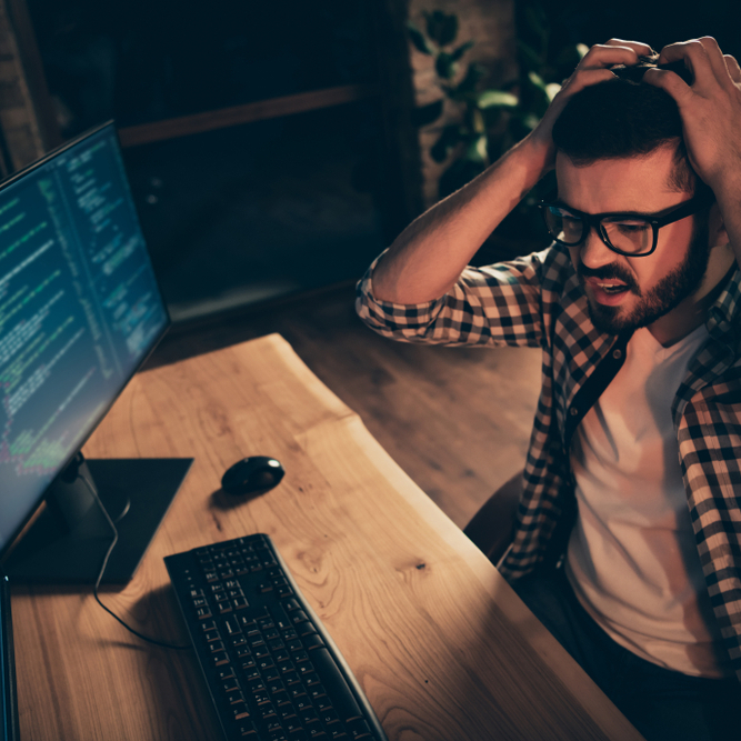 Adult man looking frustrated as he stares at a computer screen