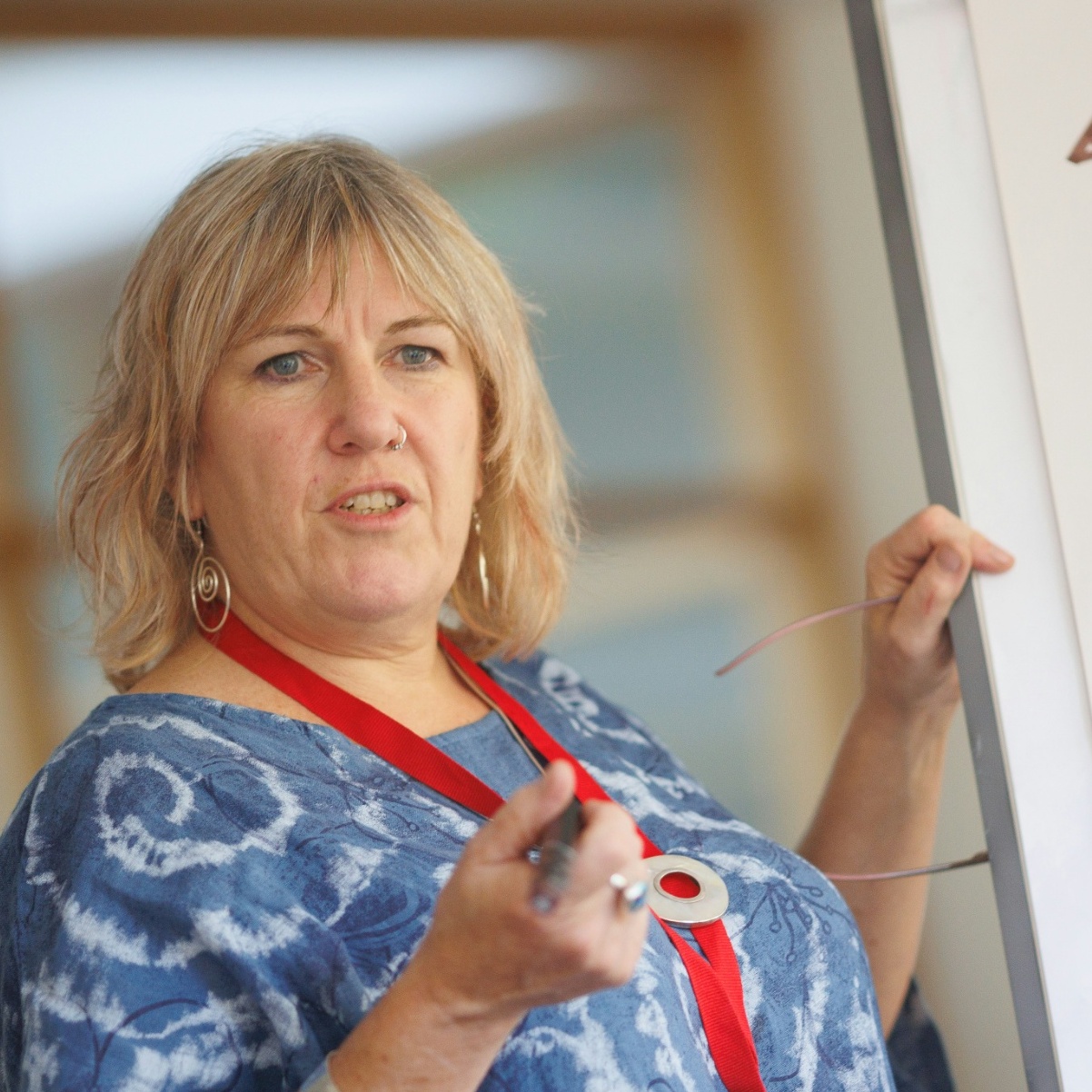 A compilation image of a woman teaching a class and a SpaceX rocket taking off.