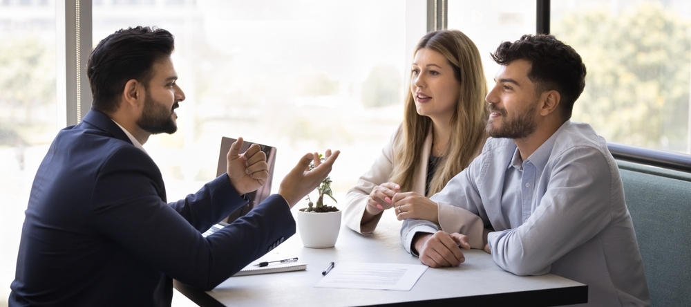 A married couple sitting and chatting with a financial advisor