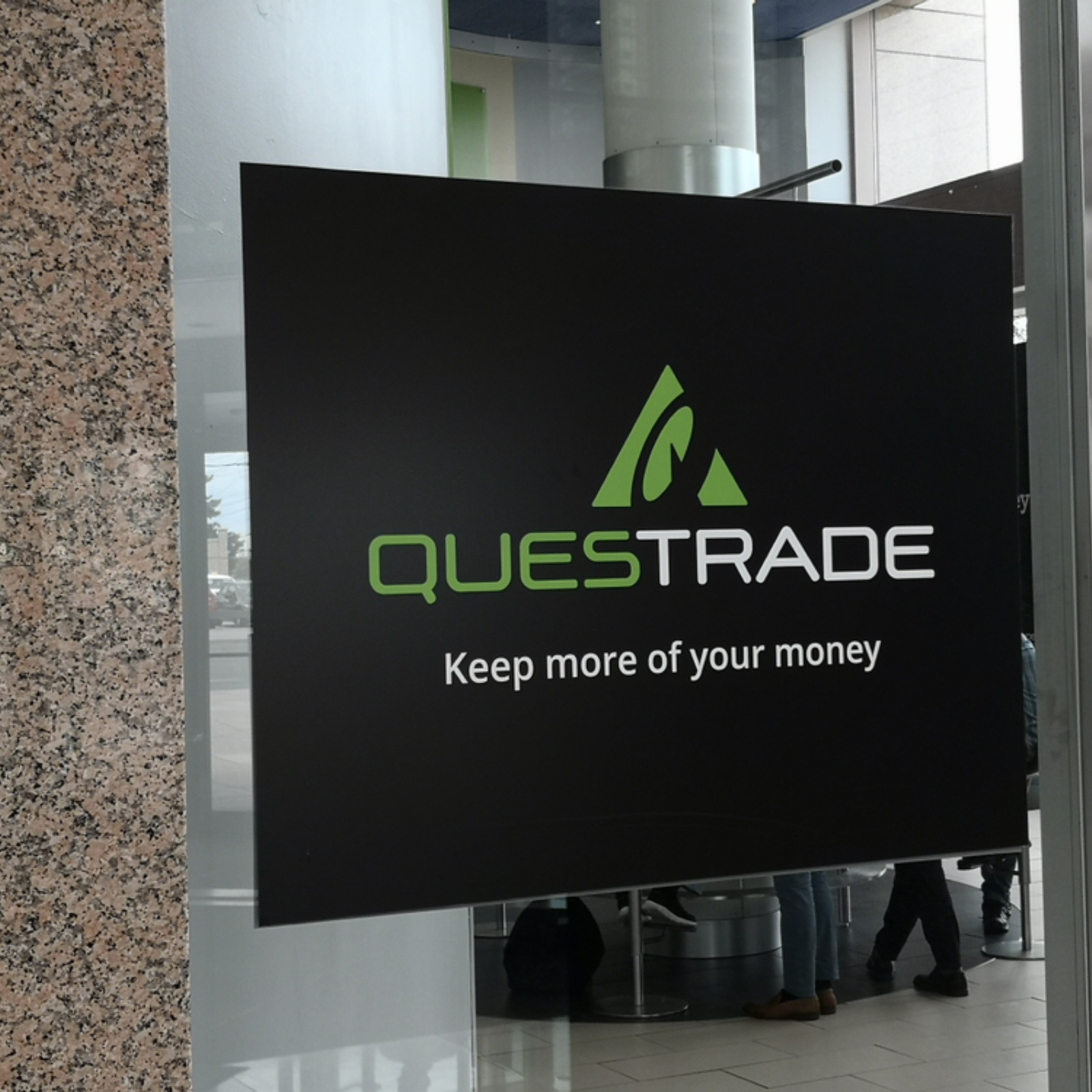Questrade sign at Toronto office + Close-up of a smartphone screen displaying the Uber app