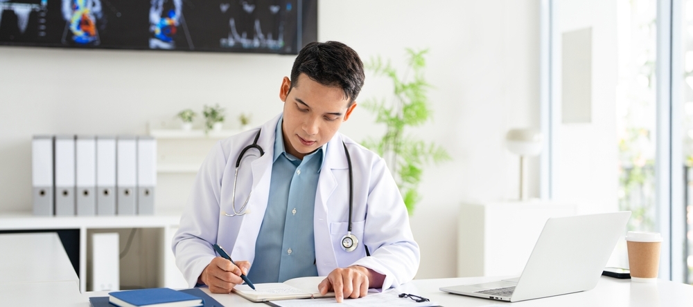 Doctor in his office signing paperwork