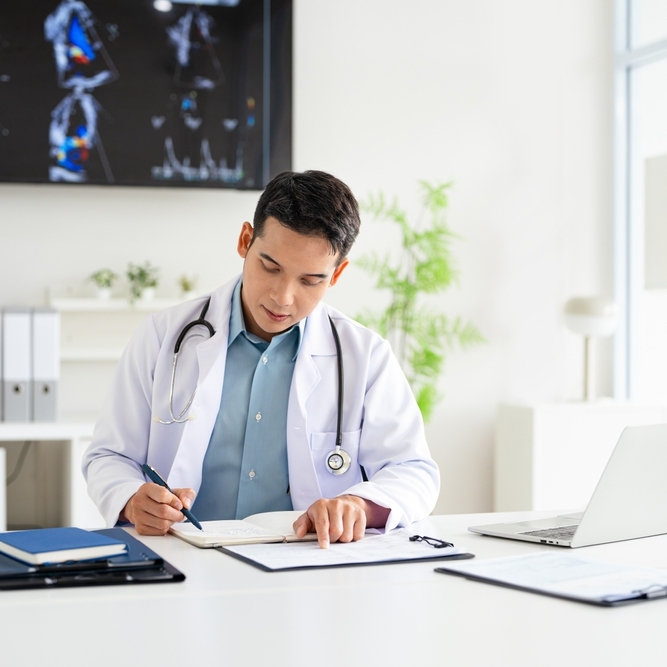 Doctor in his office signing paperwork