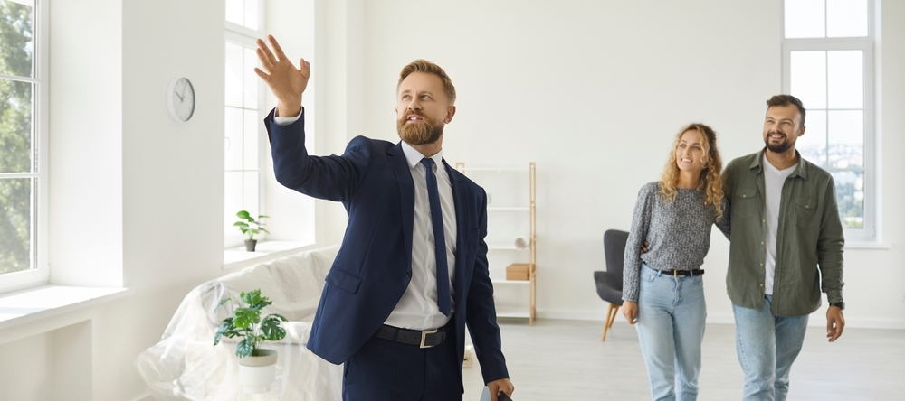 Male realtor showing male and female clients a place