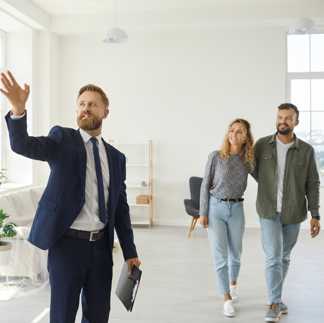 Male realtor showing male and female clients a place