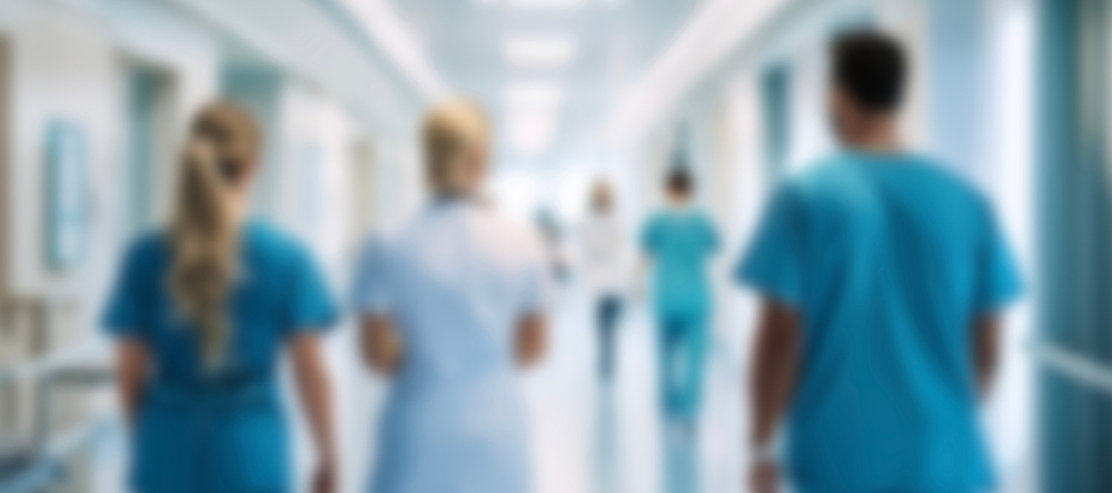 Blurry image of nurses walking down a hospital corridor