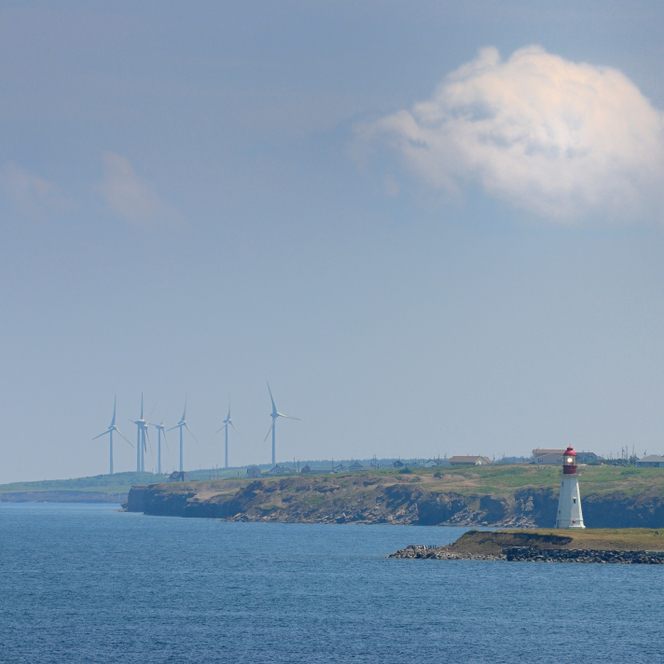 Low Point lighthouse with New Waterford wind turbines on Cape Breton Island Nova Scotia