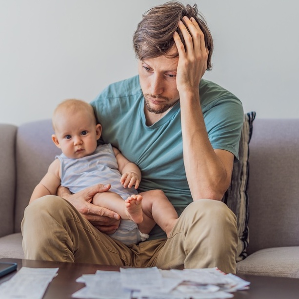 A photo of a father holding a baby looking distressed.