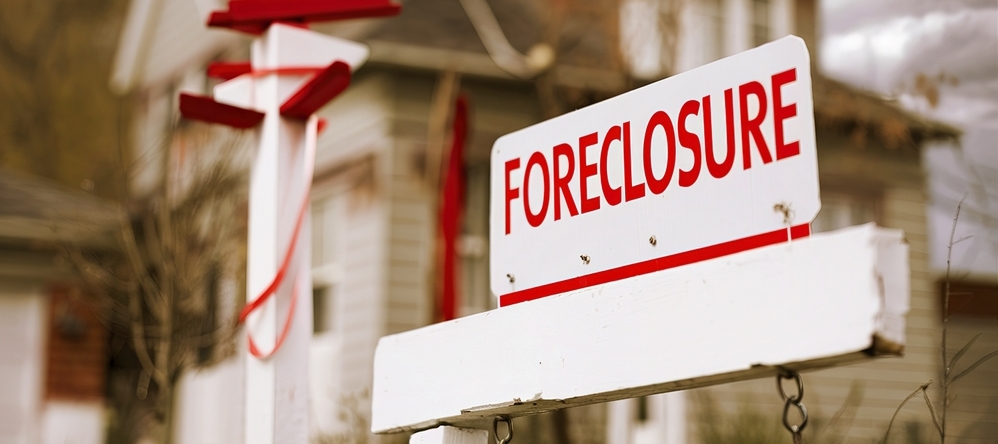 Close-up foreclosure real estate sign in front of house