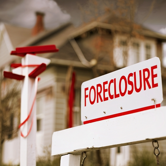 Close-up foreclosure real estate sign in front of house