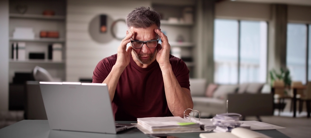 Mature man doing tax and budget. Financial overload and debt