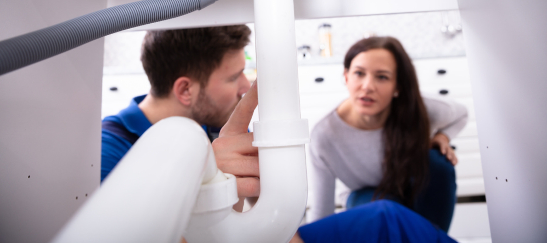 Homeowner and plumber discussing a plumbing issue in a home