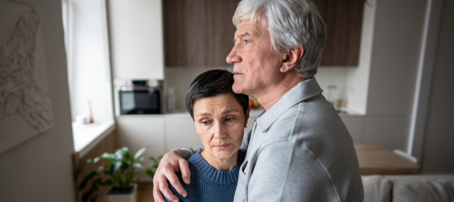 Anxious scared elderly couple embracing, facing troubles together.