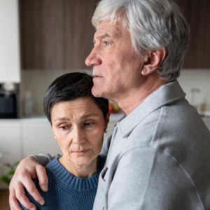 Anxious scared elderly couple embracing, facing troubles together.