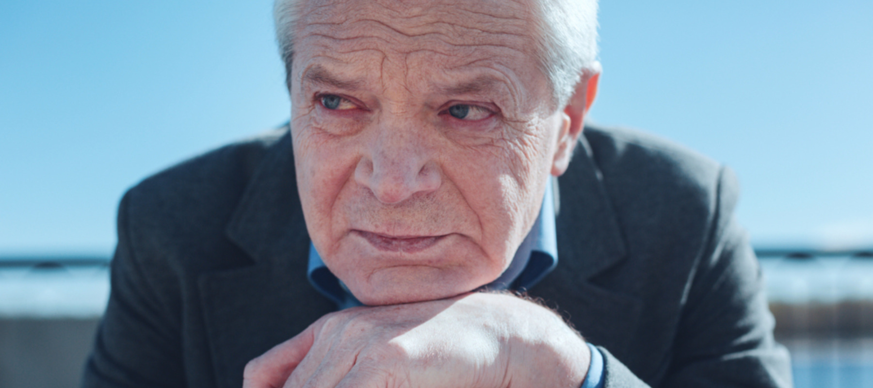 Concerned elderly retiree sitting on a bench