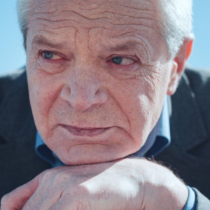 Concerned elderly retiree sitting on a bench