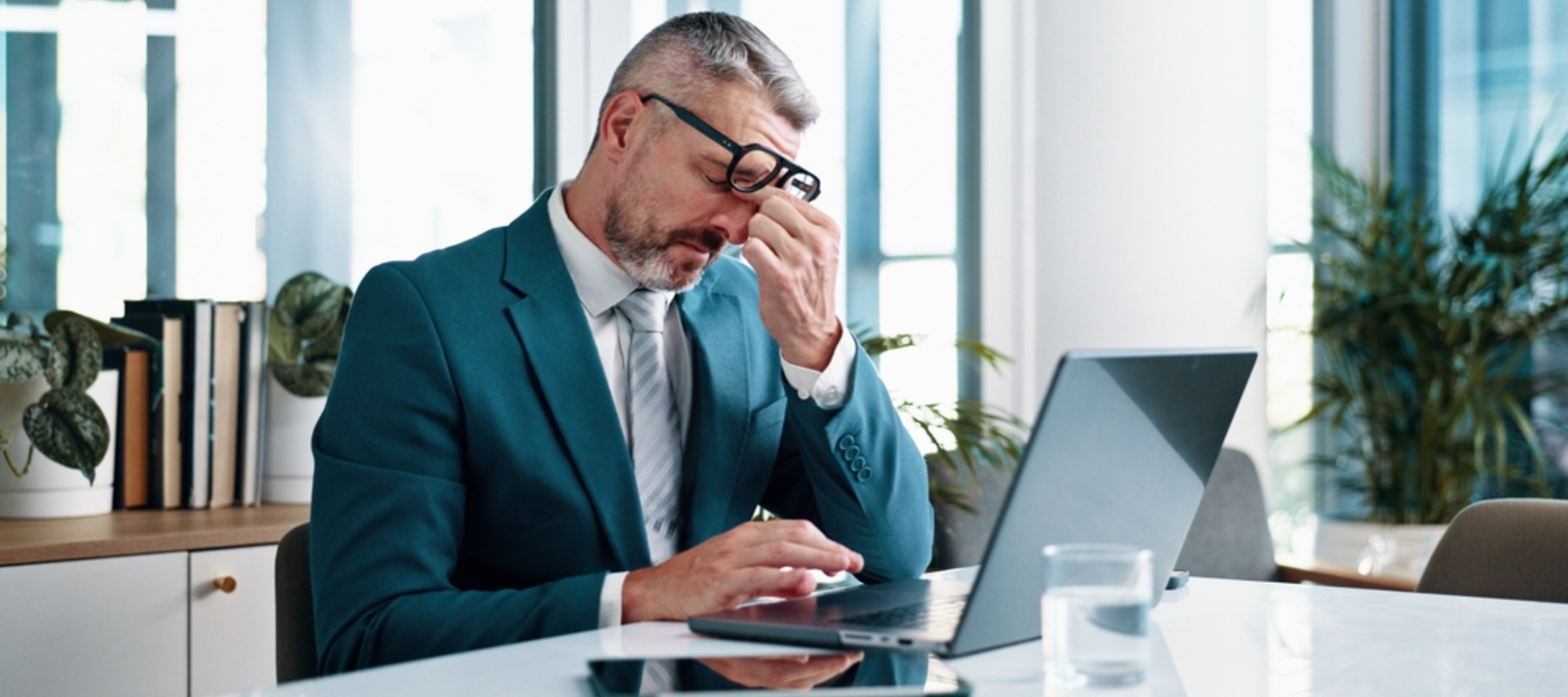 Mature businessman, headache and laptop in office for stress, crisis or mistake at investment agency.