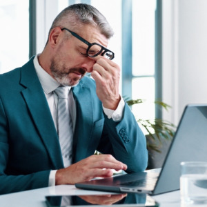 Mature businessman, headache and laptop in office for stress, crisis or mistake at investment agency.