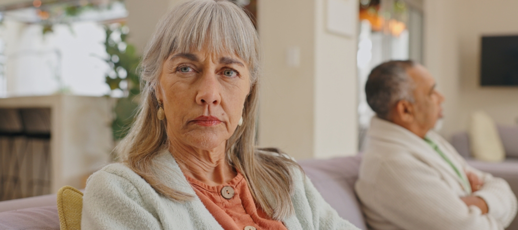 Older woman on the couch with her spouse looking concerned
