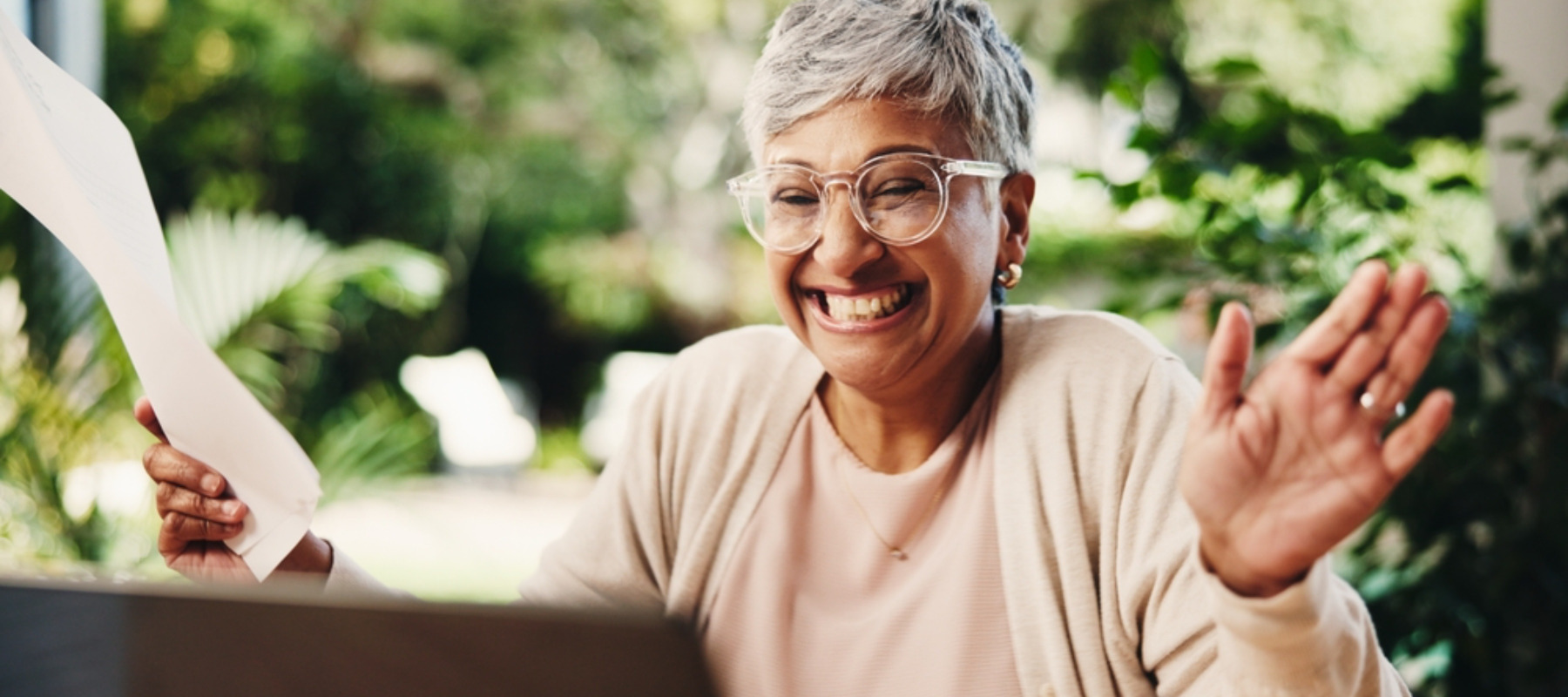 Older woman business owner looking happy as she looks at her laptop