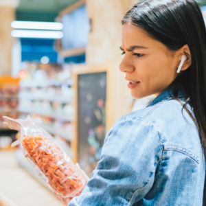 Young woman examines food at a grocery store
