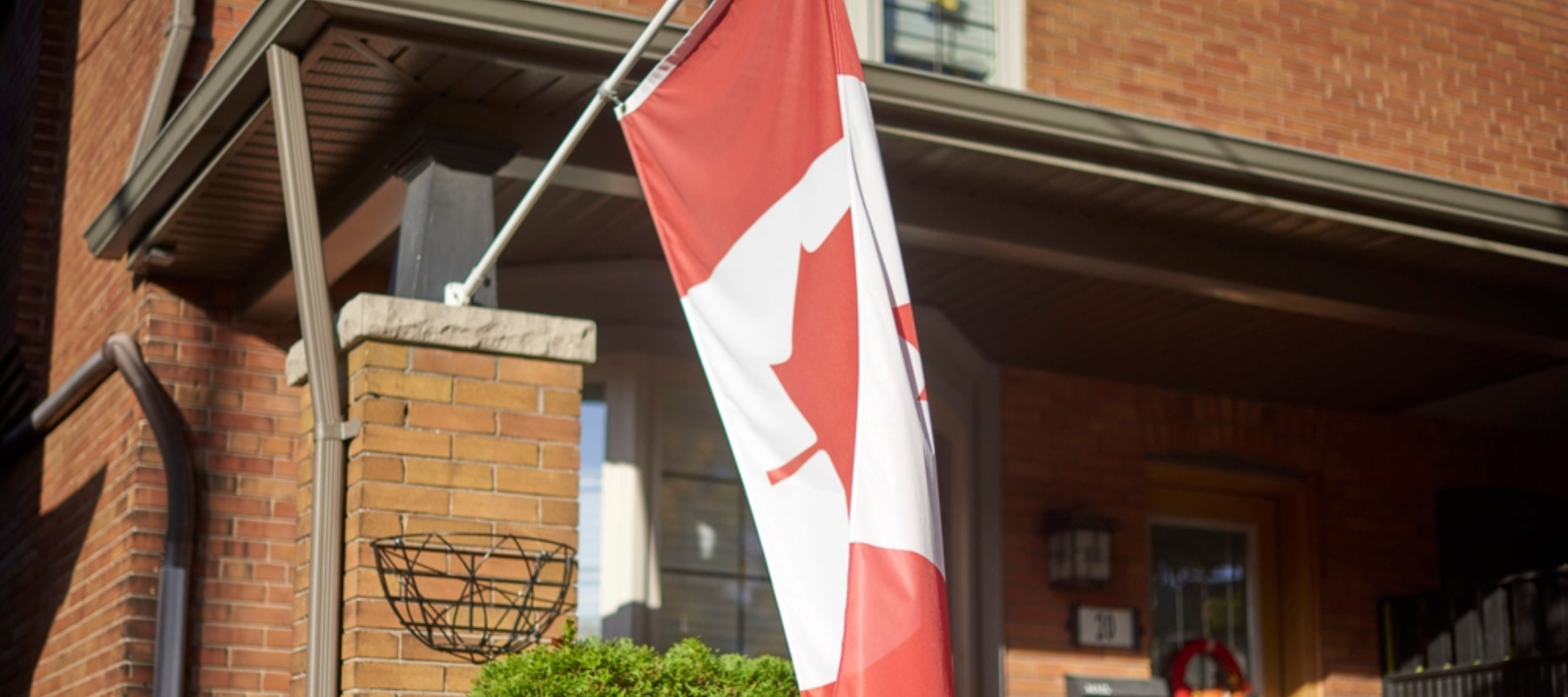 Toronto Ontario, Canada- October 21st, 2022: the front exterior of a house with a Canadian flag on it.