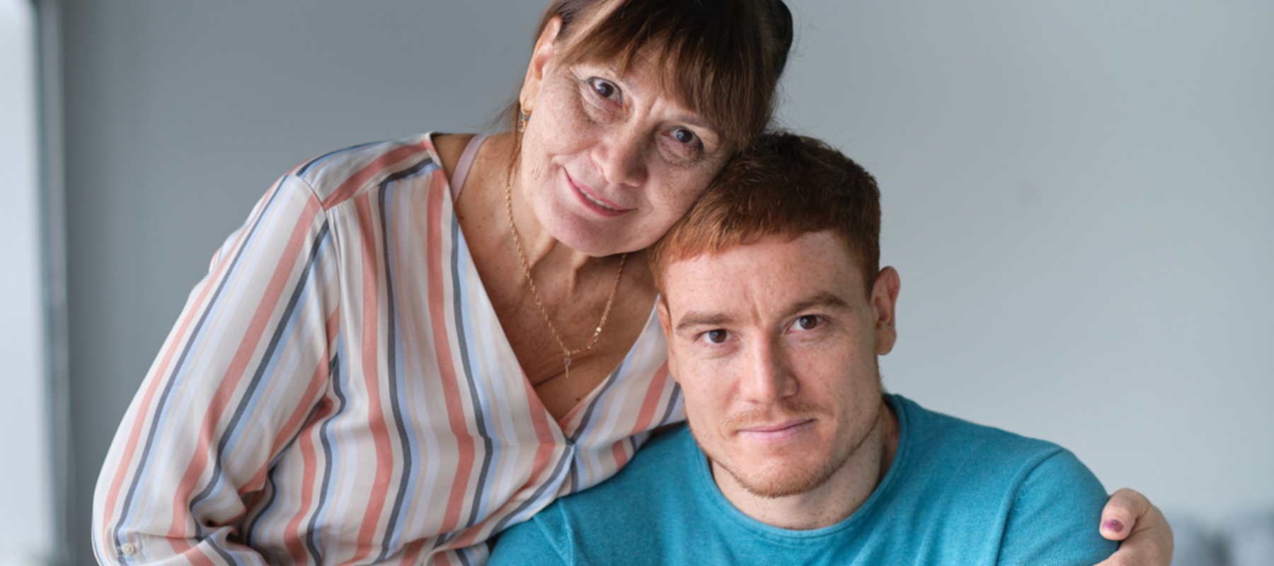 Mother and her adult son embracing each other