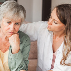 Loving adult daughter talking to sad mother