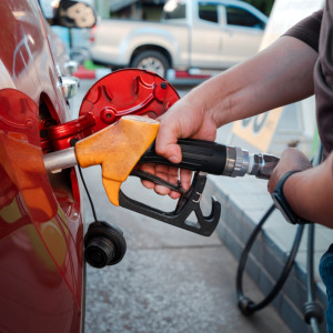 Oil drilling site in Rocky View County Alberta Canada, January 20 2024 + Closeup of hands refueling gasoline into a red car